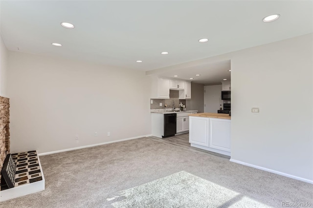 unfurnished living room with sink and light carpet