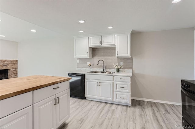 kitchen featuring butcher block countertops, sink, dishwasher, tasteful backsplash, and white cabinets