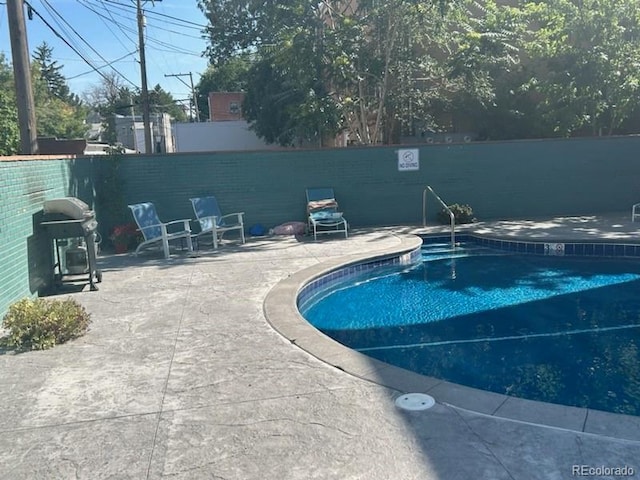 view of pool featuring grilling area and a patio