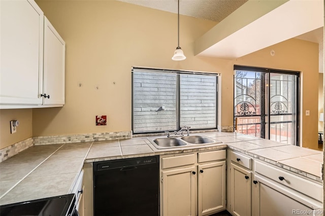 kitchen featuring decorative light fixtures, dishwasher, lofted ceiling, a peninsula, and a sink