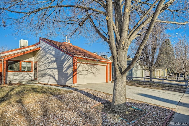 view of side of home featuring concrete driveway and an attached garage