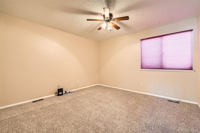 carpeted spare room featuring visible vents, baseboards, a textured ceiling, and a ceiling fan