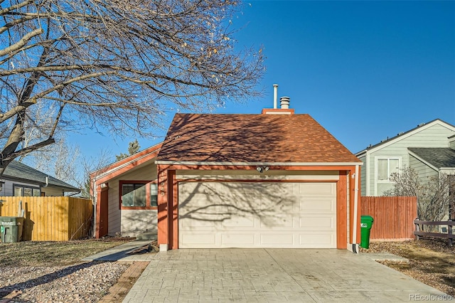 view of front of property with an attached garage, fence, driveway, and roof with shingles