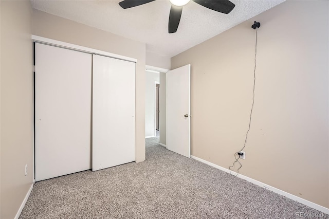 unfurnished bedroom with a ceiling fan, a textured ceiling, a closet, carpet flooring, and baseboards