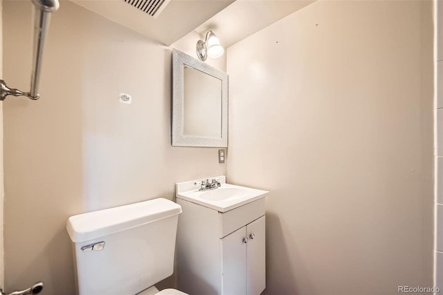 bathroom featuring visible vents, toilet, and vanity