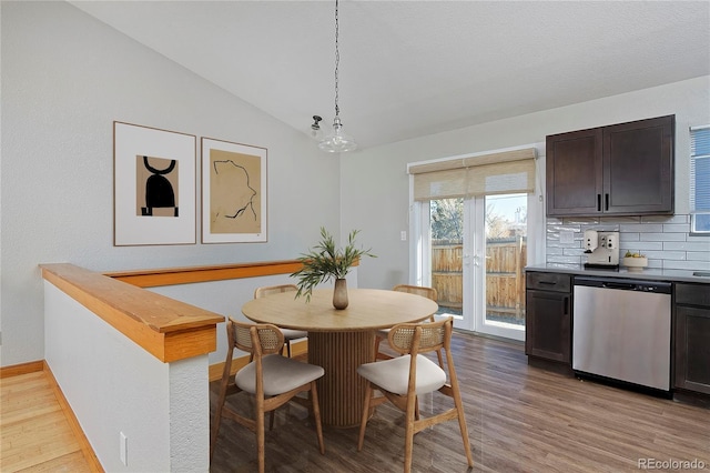 dining room featuring light hardwood / wood-style floors and lofted ceiling