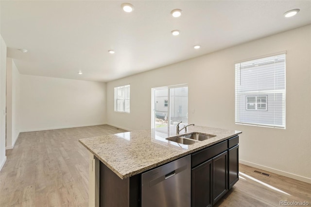 13467 Valentia St, Thornton, CO 80602 - kitchen featuring dishwasher, light wood-style flooring, a kitchen island with sink, light stone counters, and open floor plan