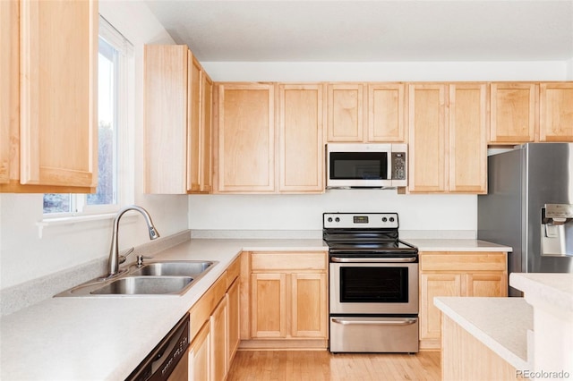 kitchen featuring sink, light brown cabinets, stainless steel appliances, and light wood-type flooring