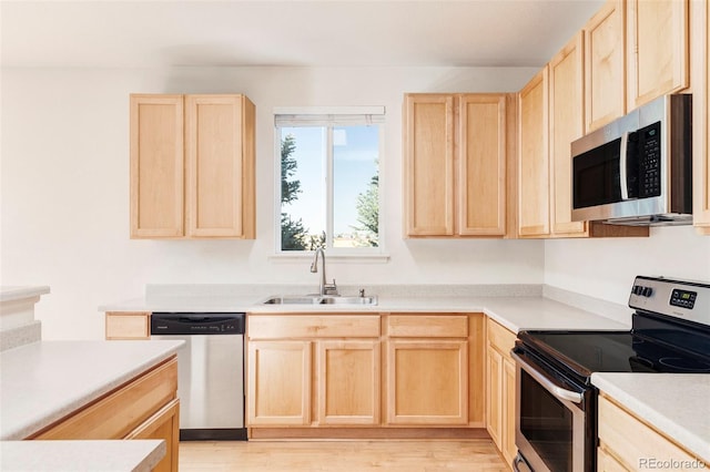 kitchen featuring sink, light brown cabinets, stainless steel appliances, and light wood-type flooring