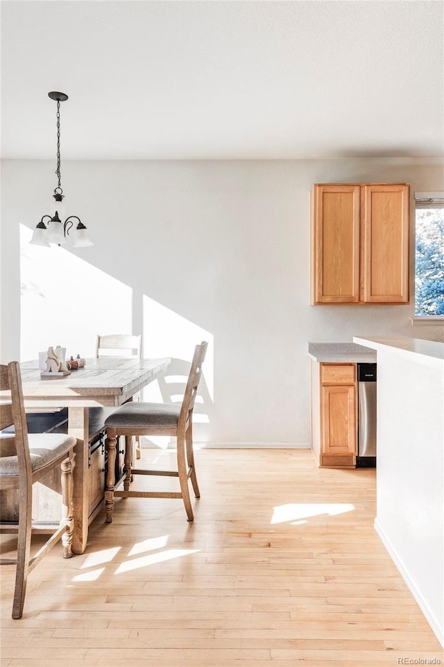 dining space with light wood-type flooring and a chandelier