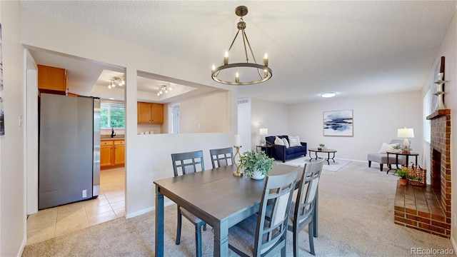 1820 W 104th Pl, Northglenn, CO 80234 - dining area featuring light carpet, a chandelier, a brick fireplace, and light tile patterned floors