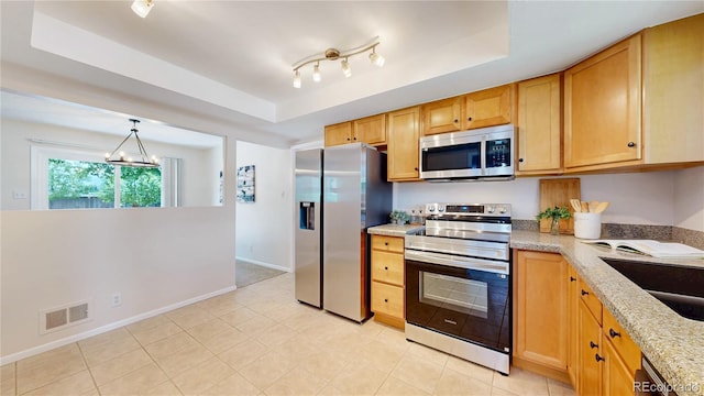 1820 W 104th Pl, Northglenn, CO 80234 - kitchen with appliances with stainless steel finishes, a tray ceiling, light stone counters, and light tile patterned floors