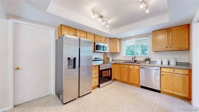 1820 W 104th Pl, Northglenn, CO 80234 - kitchen featuring appliances with stainless steel finishes, a tray ceiling, light tile patterned flooring, light countertops, and light brown cabinets