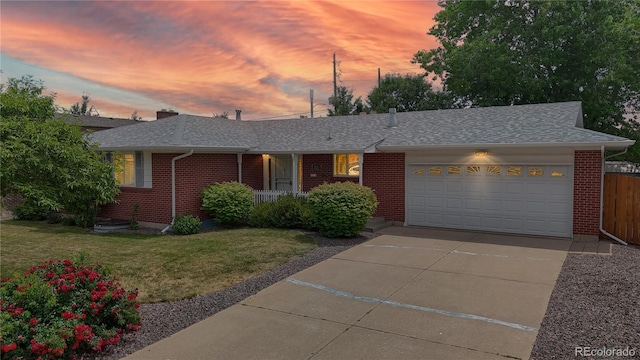 1820 W 104th Pl, Northglenn, CO 80234 - view of front facade featuring brick siding, an attached garage, a shingled roof, concrete driveway, and covered porch