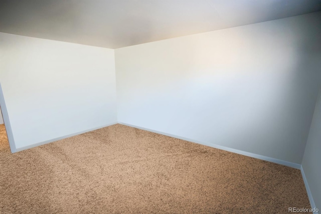 carpeted empty room featuring baseboards