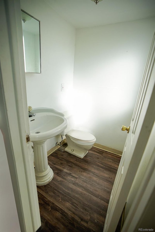 bathroom featuring baseboards, toilet, and wood finished floors