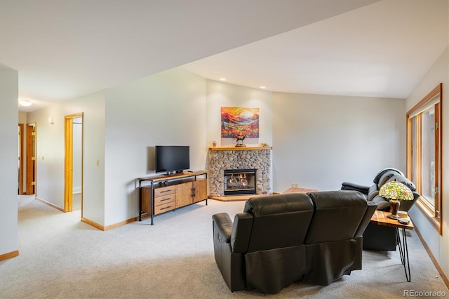 living room featuring a fireplace, vaulted ceiling, and light colored carpet