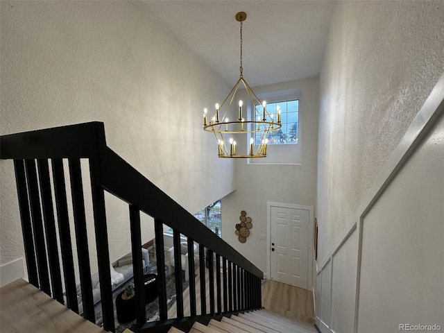 stairs featuring an inviting chandelier and hardwood / wood-style floors