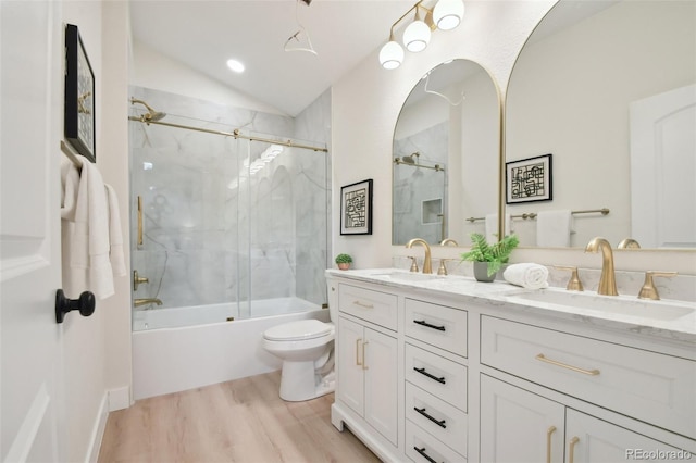 full bathroom featuring combined bath / shower with glass door, hardwood / wood-style floors, toilet, lofted ceiling, and vanity