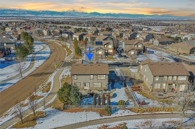 snowy aerial view with a mountain view and a residential view