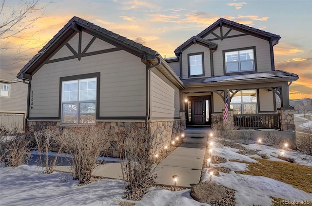 view of front of home featuring covered porch and stone siding