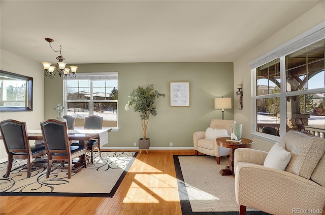 dining area featuring a chandelier, baseboards, and wood-type flooring