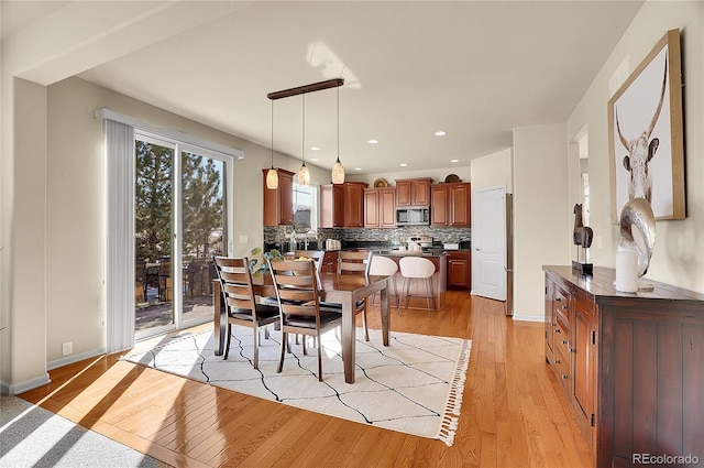 dining space with recessed lighting, baseboards, and light wood finished floors