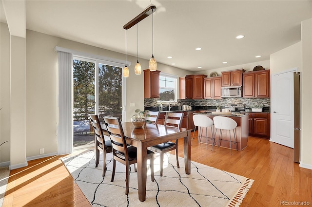 dining space with recessed lighting, baseboards, and light wood finished floors