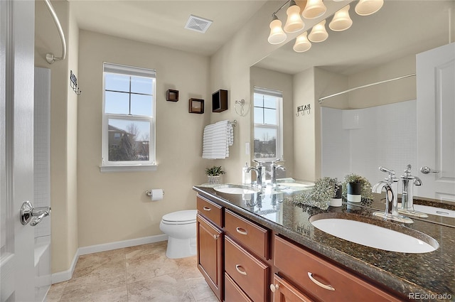 bathroom featuring toilet, visible vents, and a sink