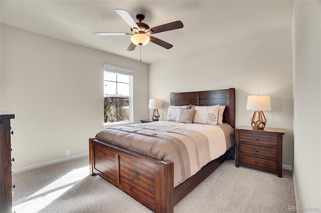 bedroom featuring light carpet, a ceiling fan, and baseboards