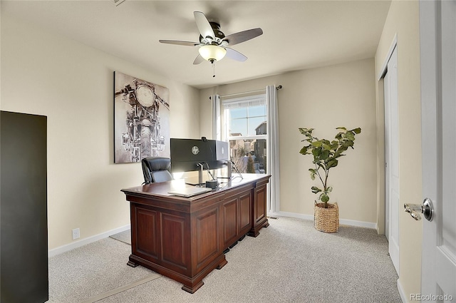 office area featuring a ceiling fan, baseboards, and light carpet