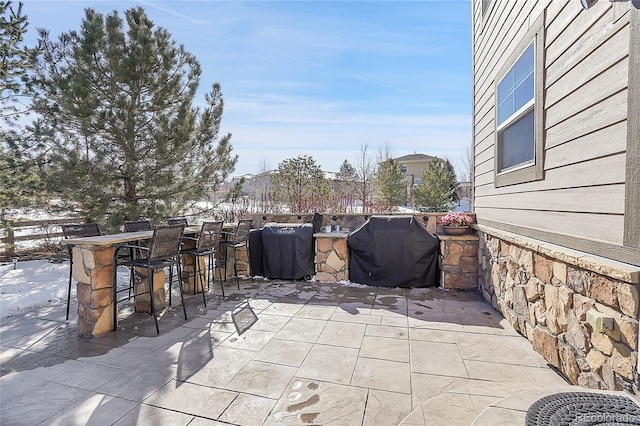 view of patio featuring outdoor dry bar and grilling area