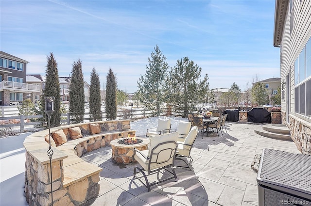 view of patio featuring an outdoor fire pit, outdoor dining area, and fence