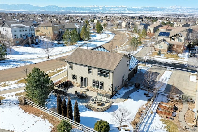 snowy aerial view featuring a residential view and a mountain view