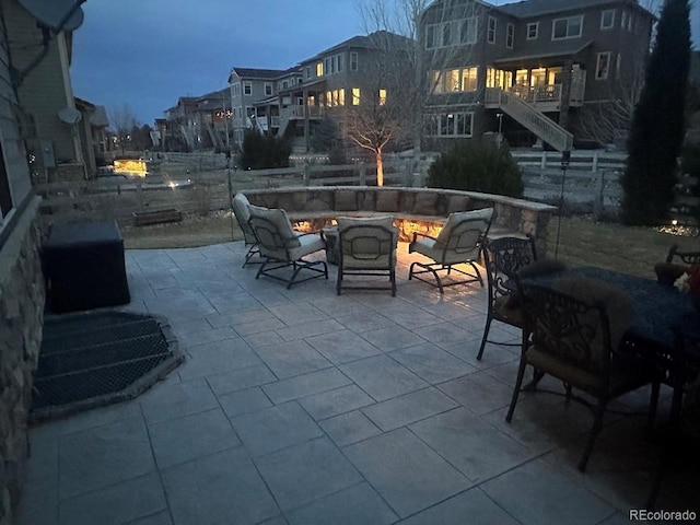 view of patio with area for grilling, a fire pit, and stairs