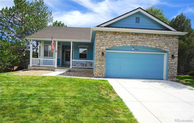 single story home with a porch, a front yard, and a garage