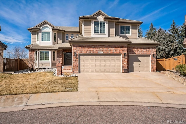 traditional home with driveway, a tile roof, fence, a garage, and brick siding