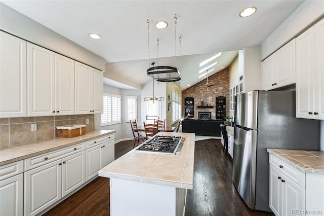 kitchen with backsplash, dark wood finished floors, vaulted ceiling, appliances with stainless steel finishes, and white cabinets