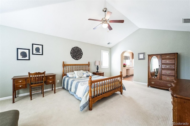 bedroom featuring light carpet, arched walkways, baseboards, and vaulted ceiling