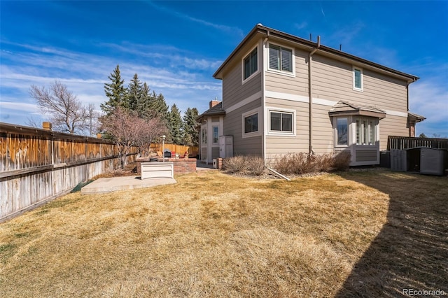 rear view of property with a patio area, a fenced backyard, and a lawn