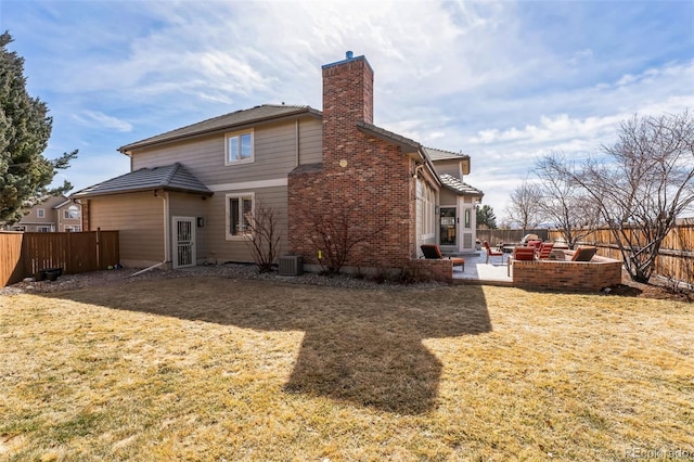 rear view of property featuring a patio, cooling unit, a yard, a fenced backyard, and a chimney