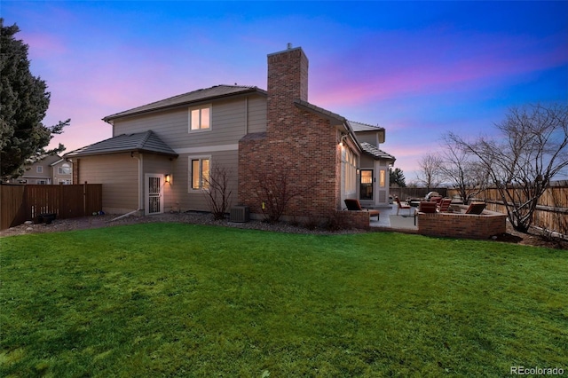 back of property featuring a yard, a fenced backyard, a chimney, and a patio