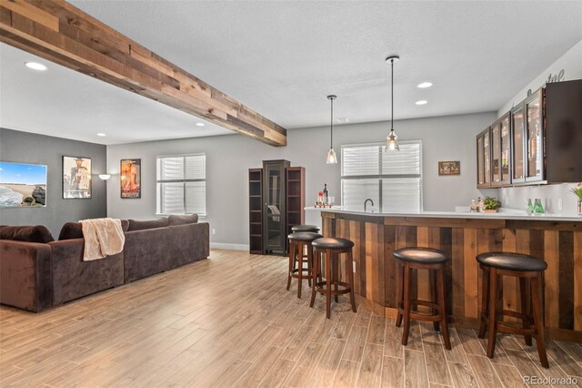 17358 W 95th Ave, Arvada, CO 80007 - indoor wet bar featuring light wood-type flooring, beamed ceiling, recessed lighting, and hanging light fixtures