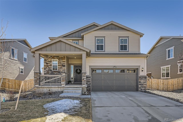 craftsman-style house with a porch, concrete driveway, board and batten siding, fence, and stone siding