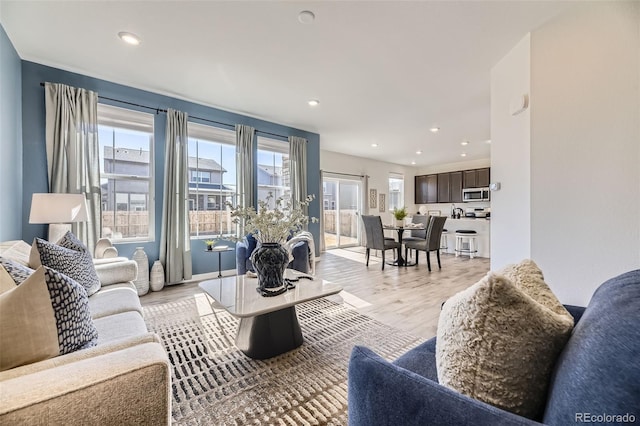 living area featuring light wood-type flooring and recessed lighting