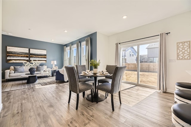 dining area with light wood finished floors and recessed lighting