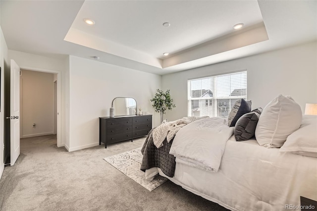 bedroom with recessed lighting, baseboards, a raised ceiling, and light colored carpet