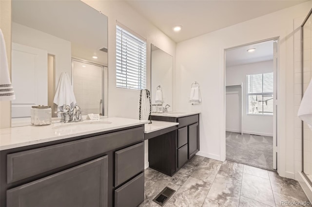 bathroom featuring a sink, two vanities, a shower stall, and visible vents