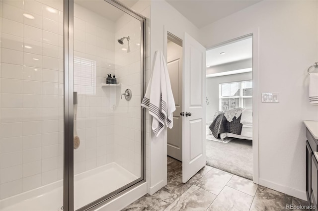 ensuite bathroom featuring a stall shower, vanity, baseboards, and ensuite bathroom