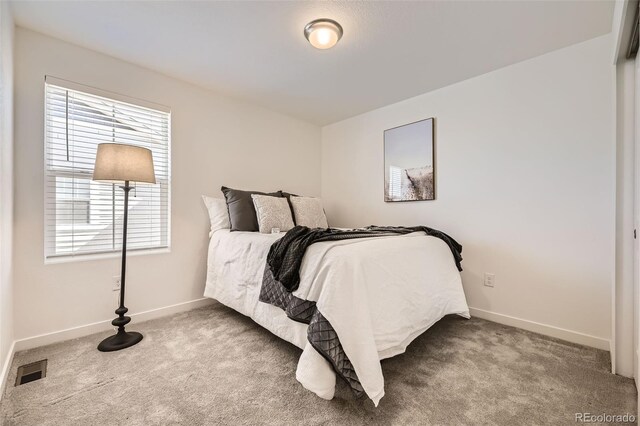 bedroom featuring carpet floors, visible vents, and baseboards